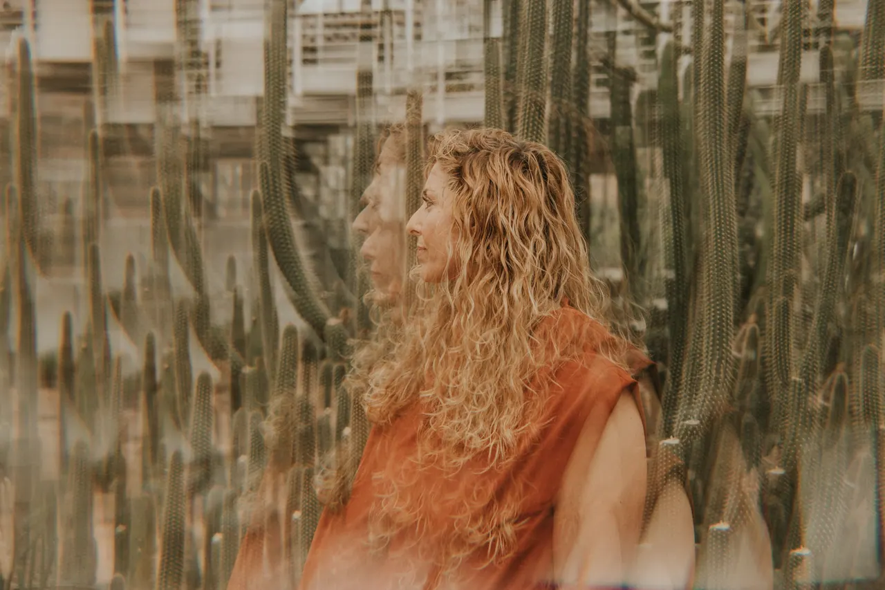 Carmen de perfil entre cactus, con un top teja