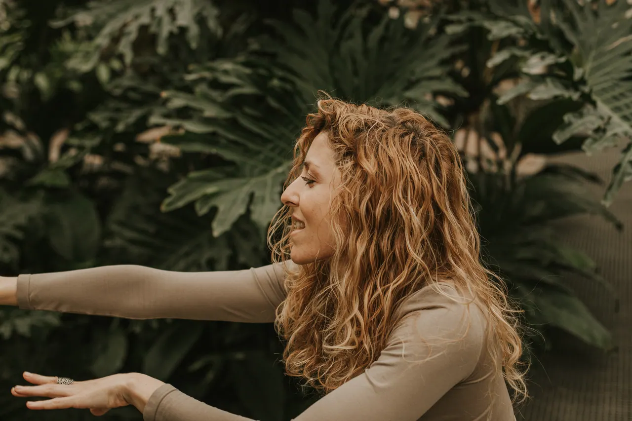 Carmen agachada mirando las plantas, con una sonrisa