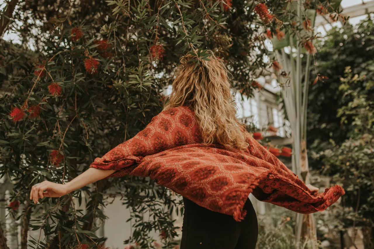 Carmen de espaldas abre los brazos y la tela del kimono rojo