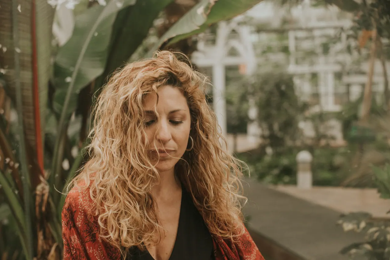 Carmen mira hacia abajo, con un kimono rojo